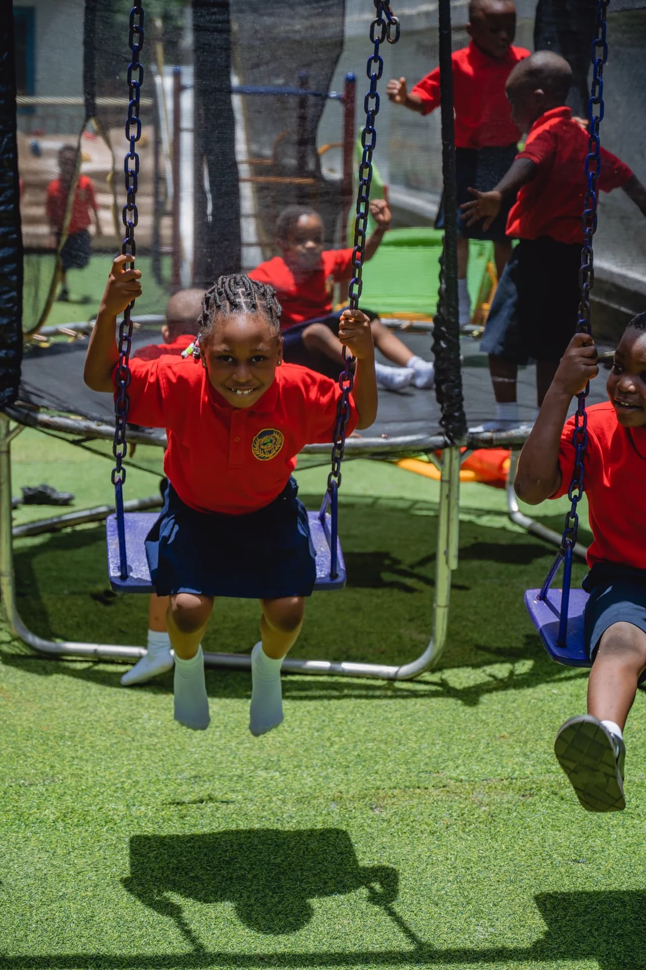 Tenderville student swinging joyfully on the playground